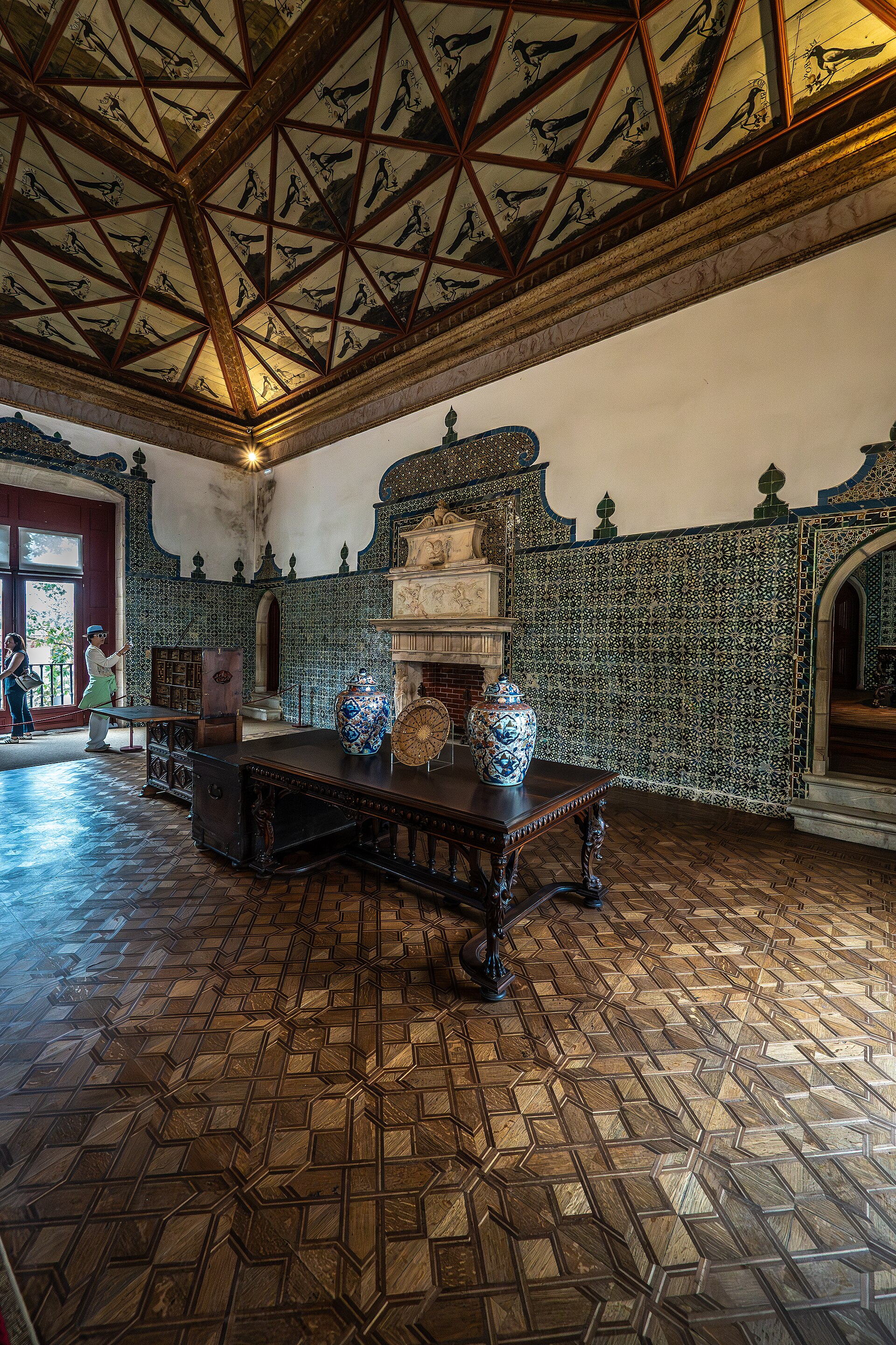 Historic room with green tiles, timber furniture and fireplace